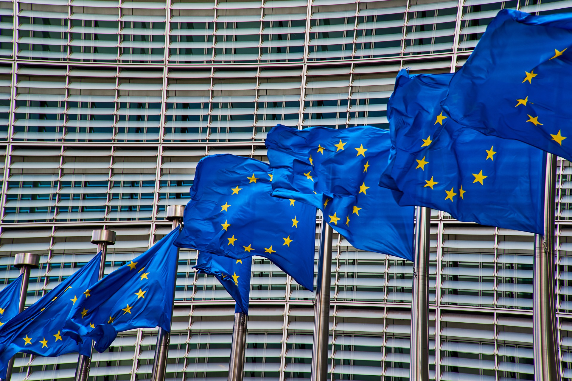 Imagen de varias banderas de Europa delante de un edificio de oficinas