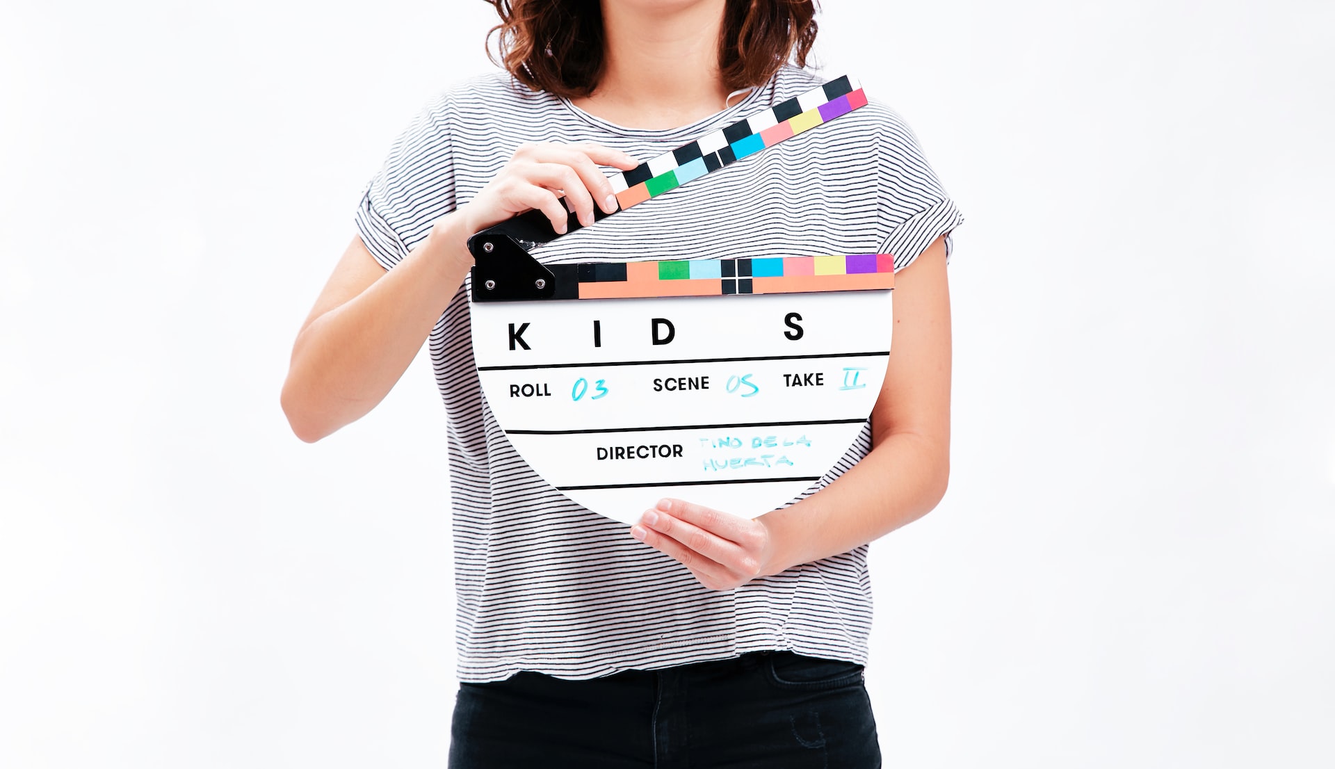 mujer sosteniendo una claqueta con nombre KIDS