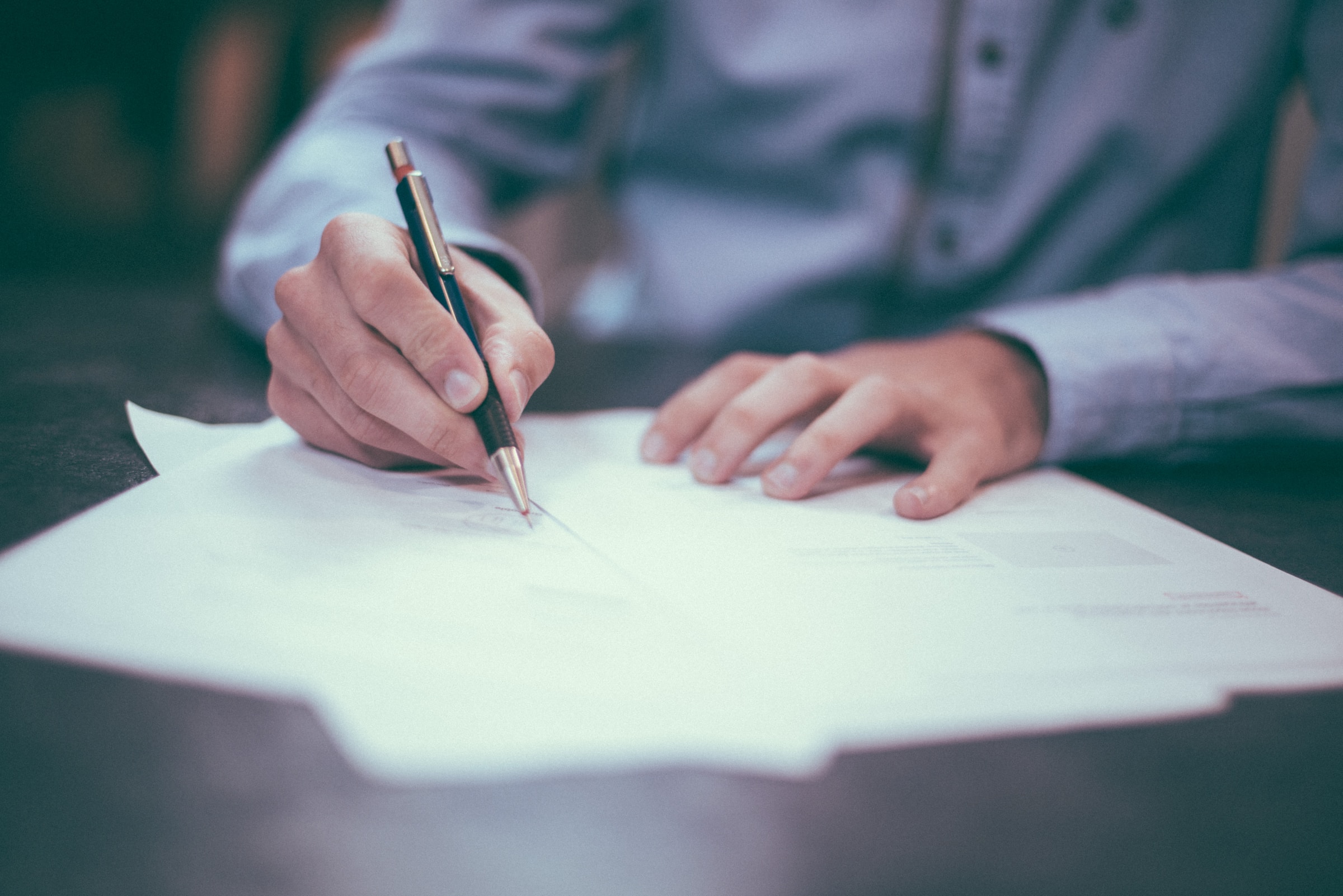 Primer plano de manos de hombre firmando papeles