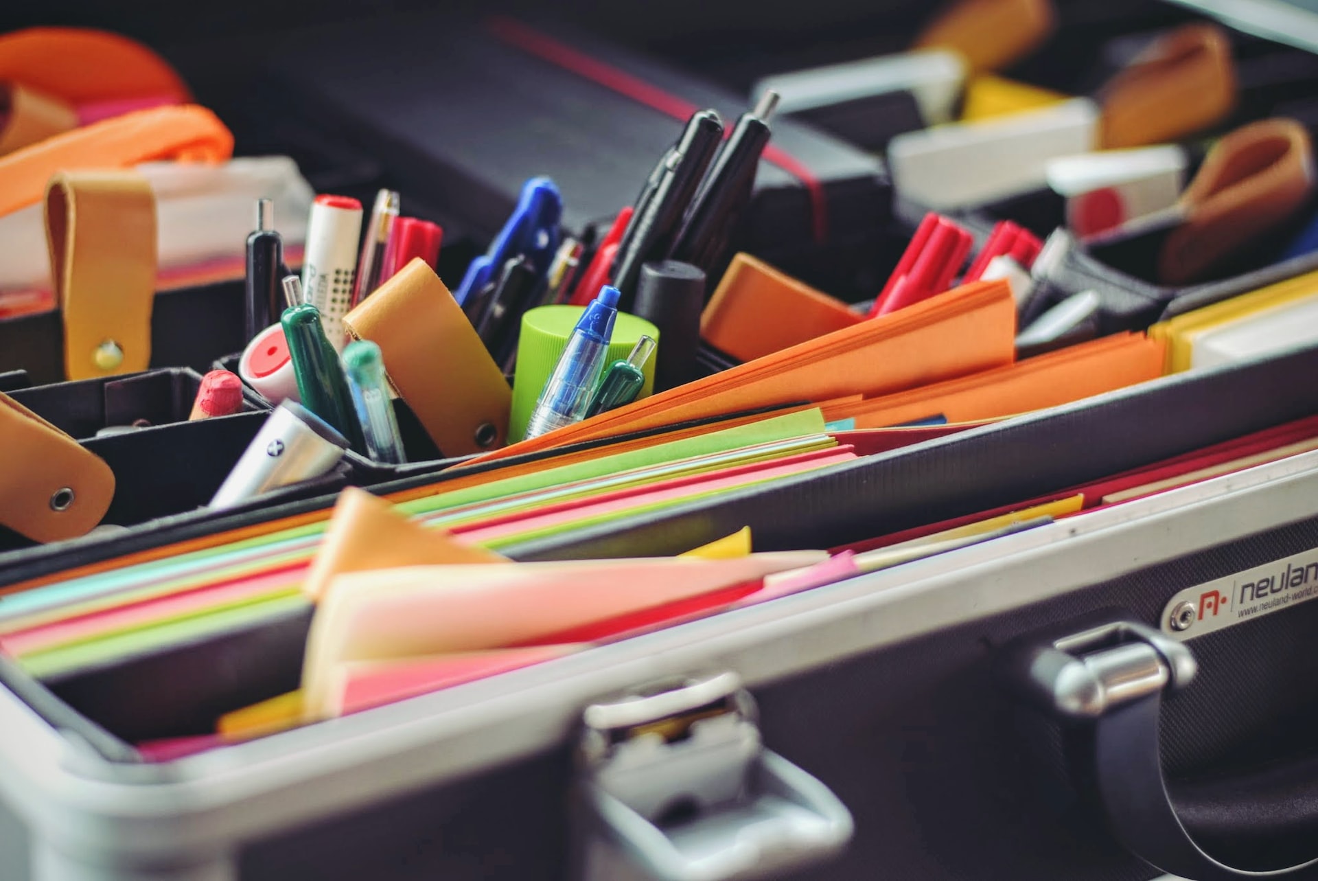 artículos de papelería colocados en maleta en compartimentos