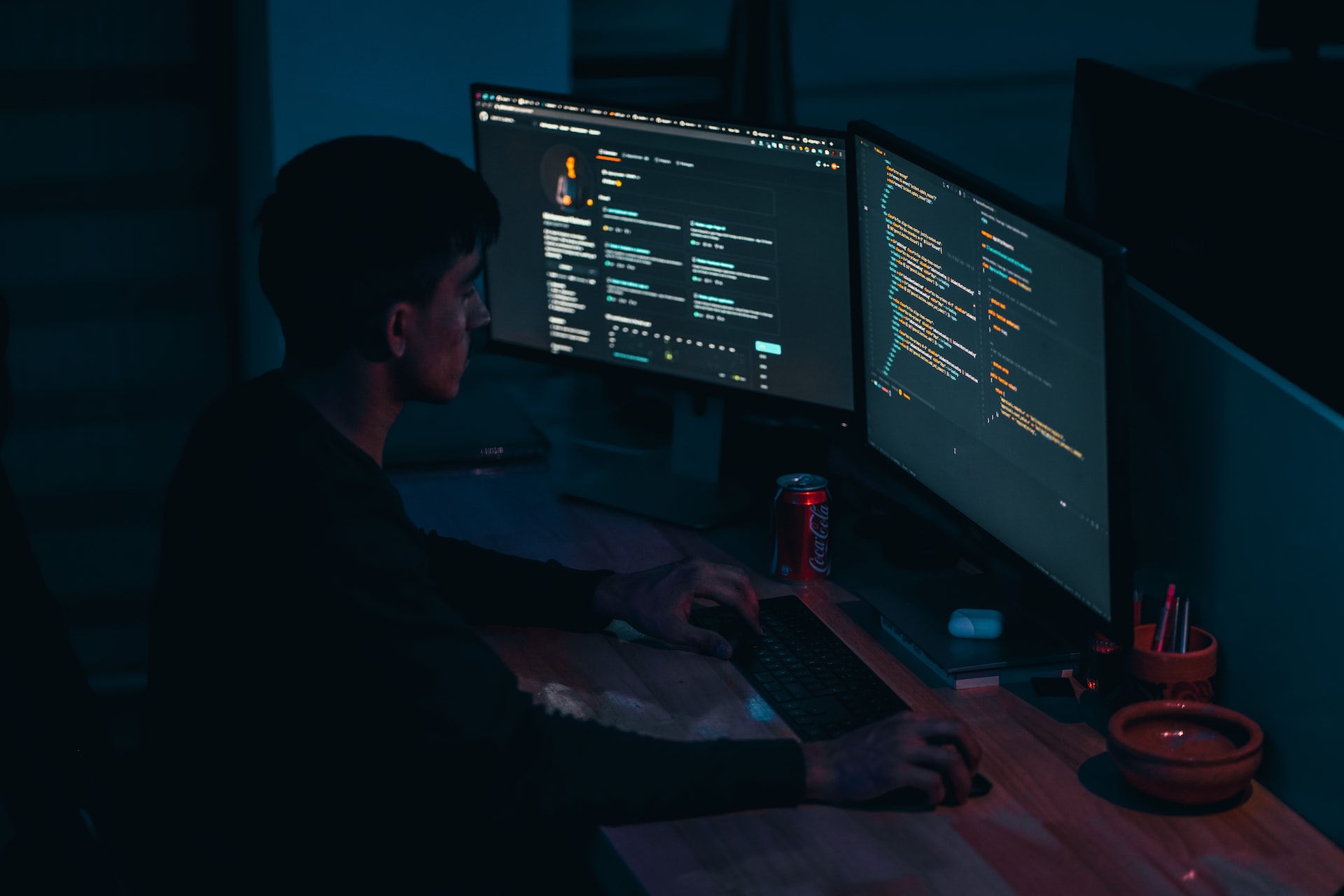 hombre programando con dos pantallas