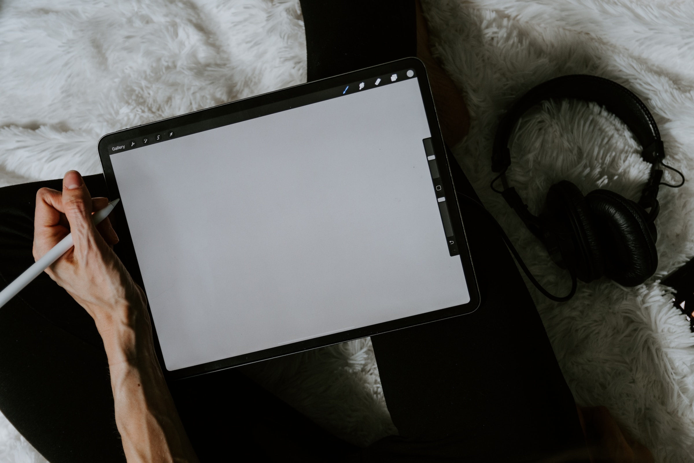 Tableta gráfica vacía y mano izquierda sujetando un lápiz digital