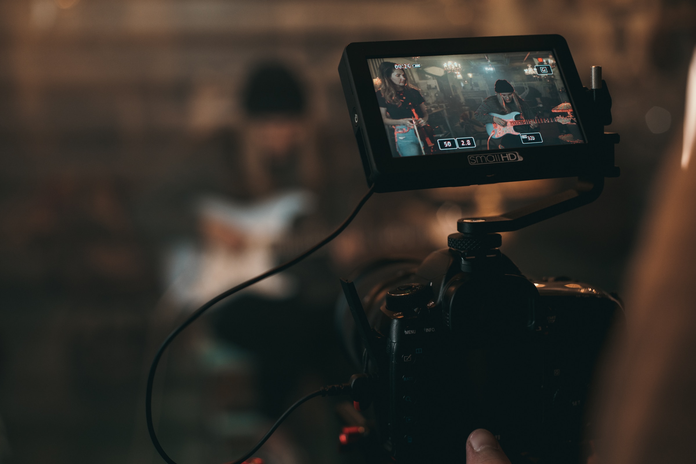 Visor de una cámara de vídeo grabando a una persona tocando la guitarra