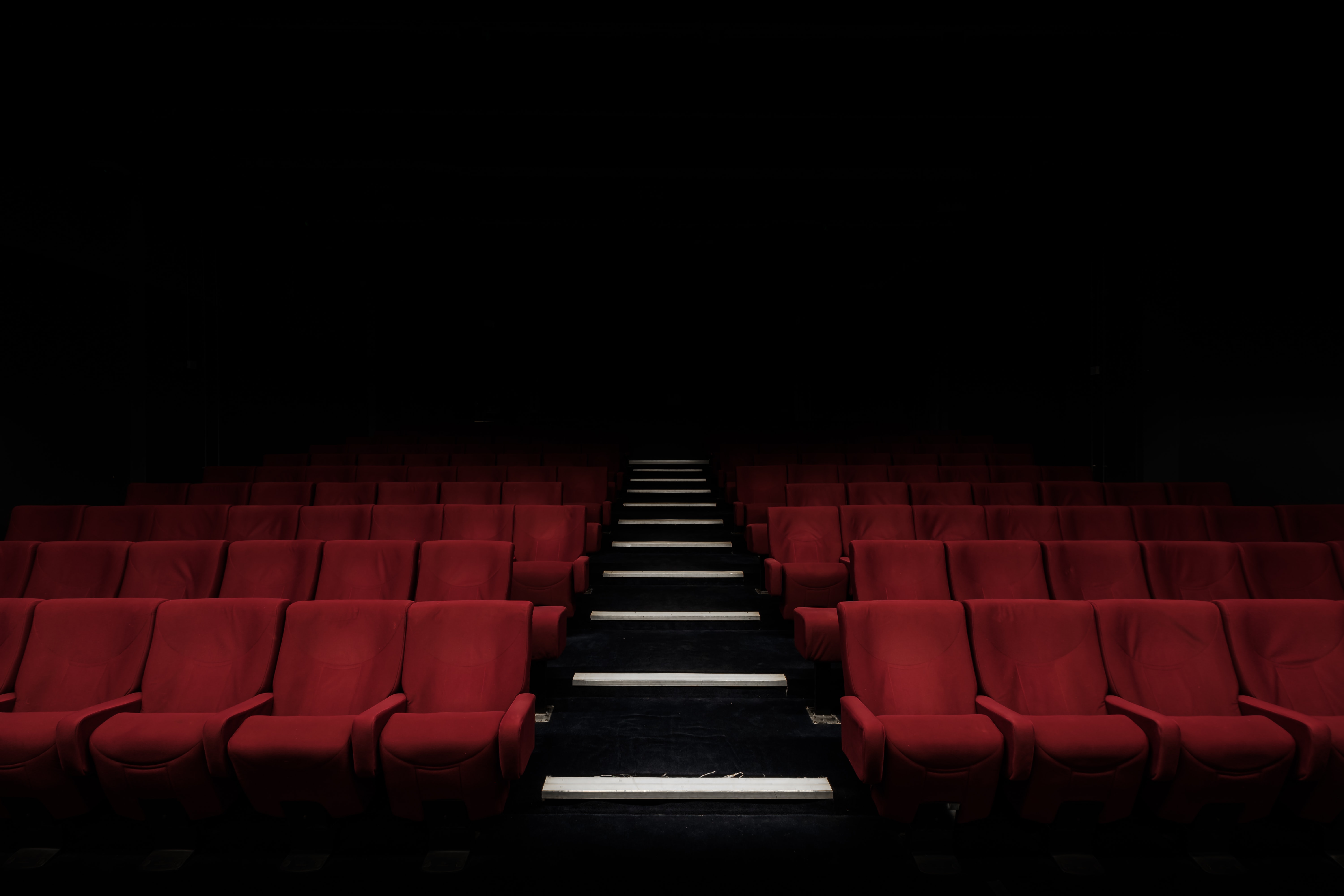 Sala de cine vacía con butacas rojas