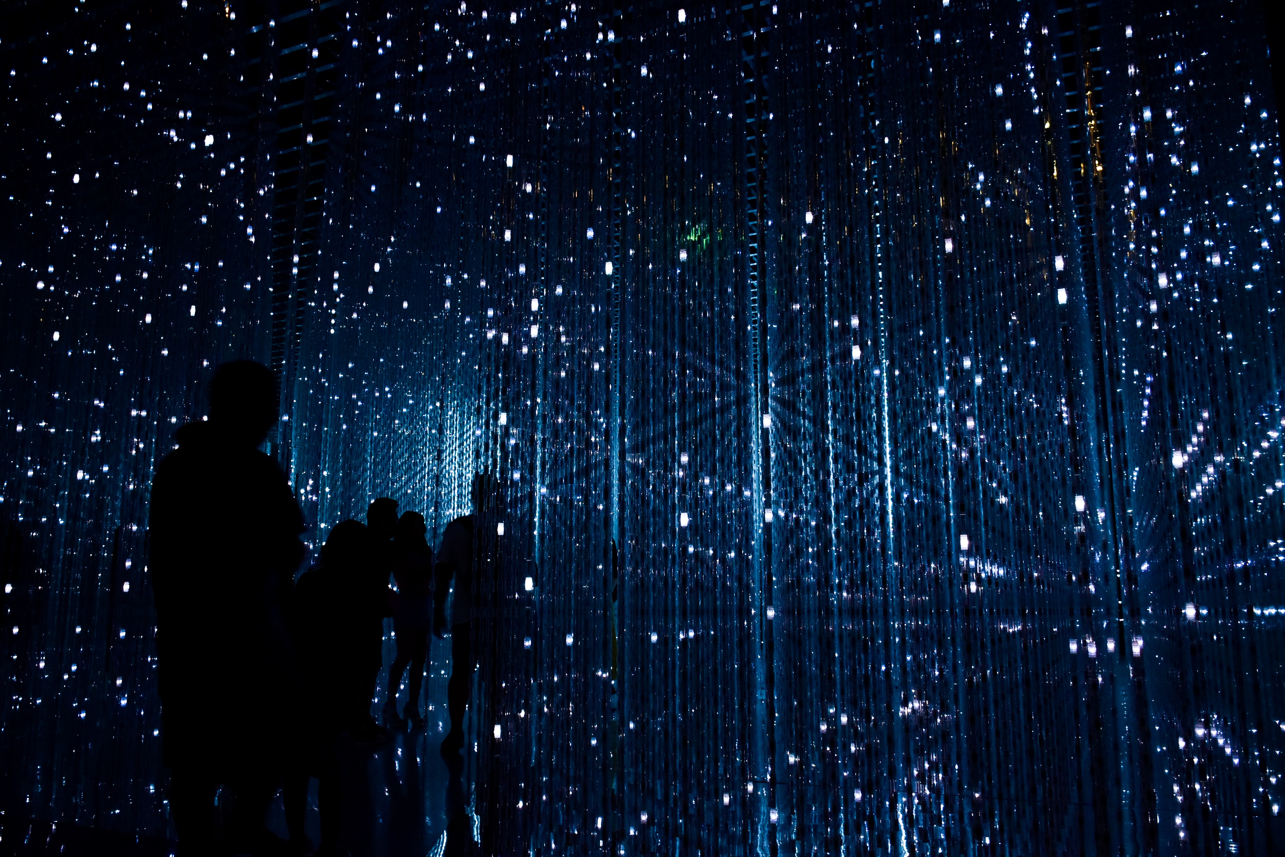 Fondo de luces con sombras humanas entre ellas