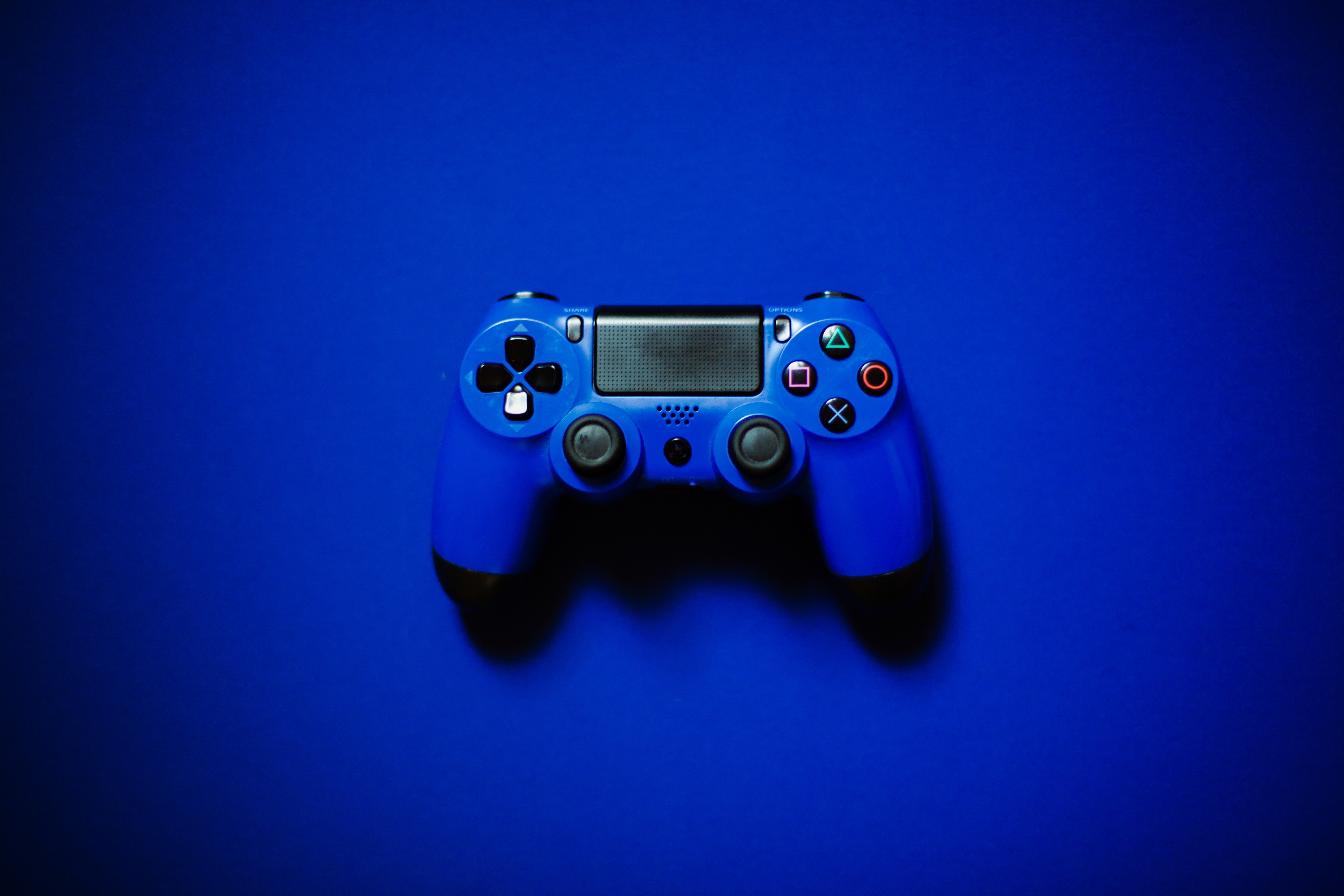 Mando azul de videoconsola sobre fondo azul