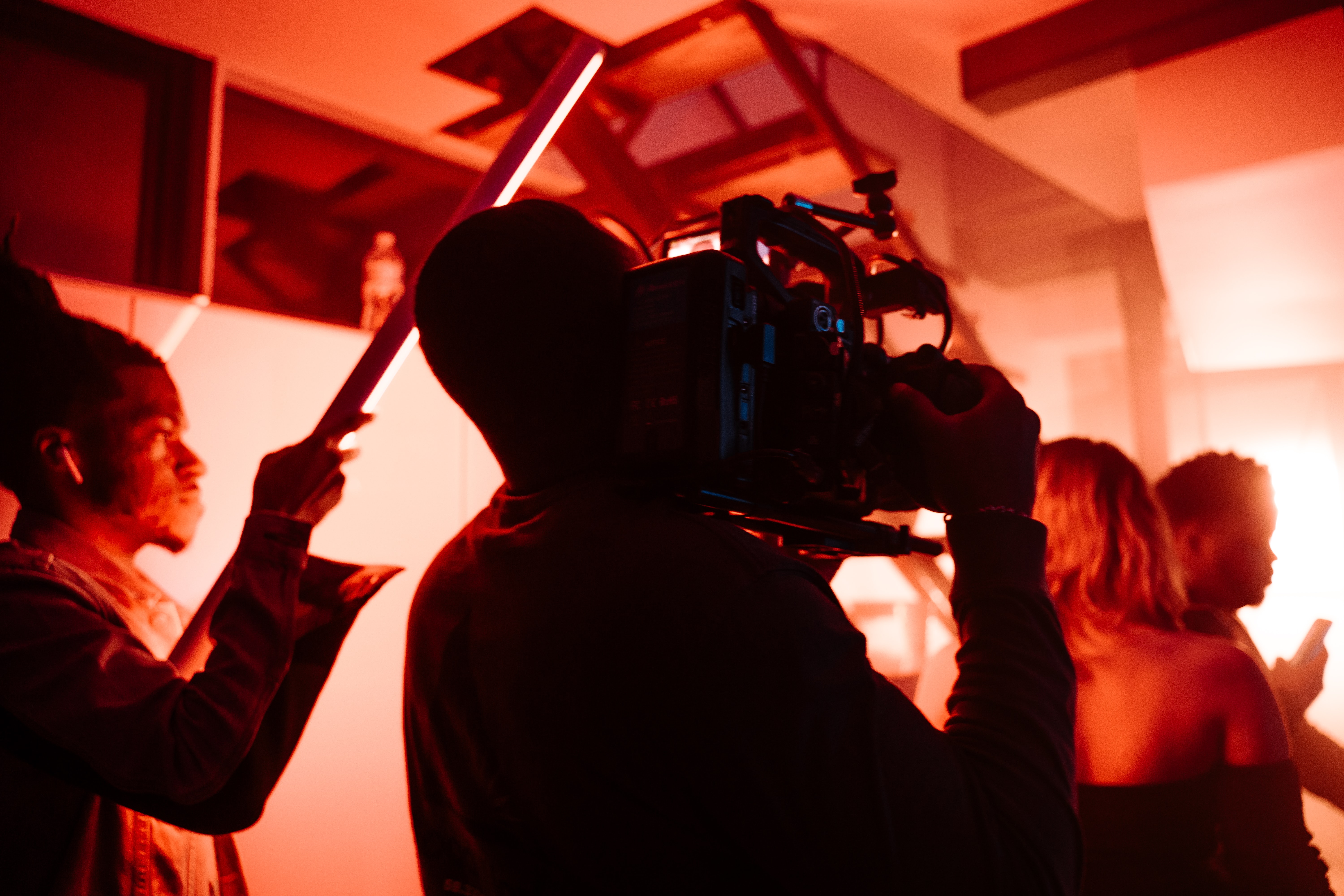 Equipo de cine rodando en habitación con luz roja tenue