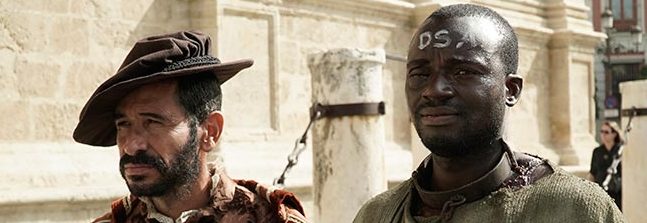 Fotograma del documental Los Negros. Una persona blanca y una persona negra esclavizada van por la calle